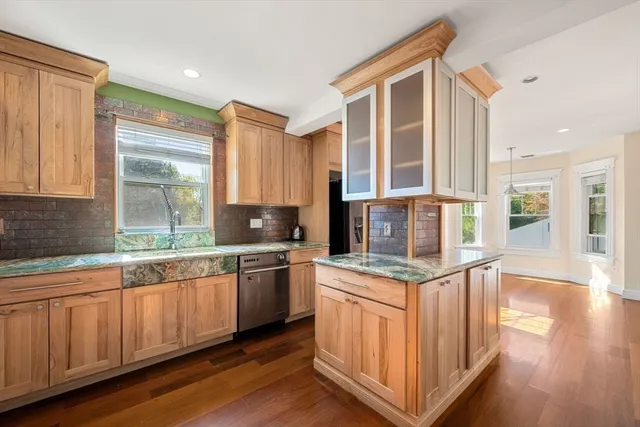 a kitchen with stainless steel appliances granite countertop a stove a sink and a microwave
