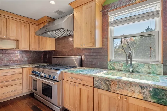 a kitchen with granite countertop a stove a sink and a granite counter tops