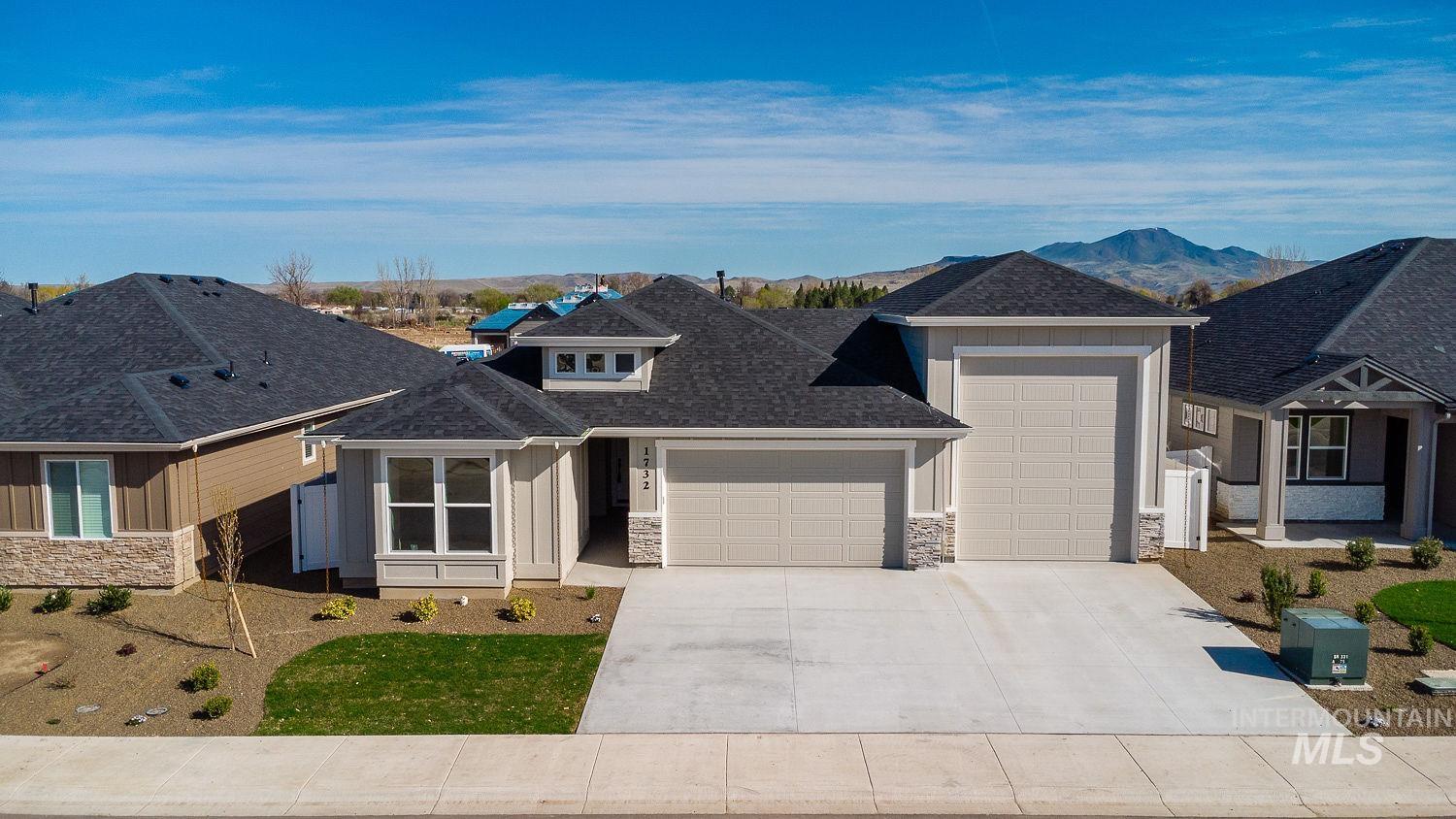 1732 Sandbar Road Emmett, ID 83617 - Photo 1 of 1 View of front facade featuring stone siding, a garage, a shingled roof, and driveway