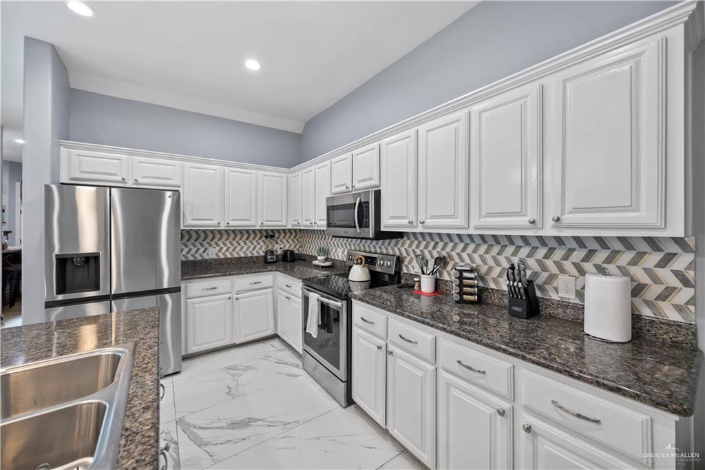 3107 South 6th Lane McAllen, TX 78503 - Photo 14 of 31 a kitchen with stainless steel appliances granite countertop a sink stove and refrigerator
