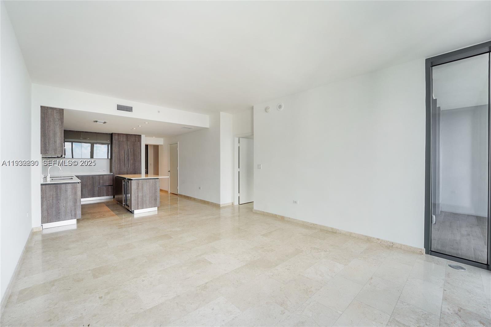88 Southwest 7th Street, Unit 2708 Miami, FL 33130 - Photo 6 of 12 an empty room with kitchen view and a window