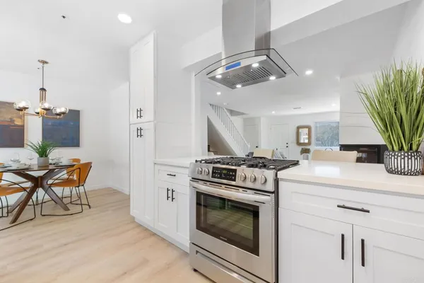 a kitchen with a stove and white cabinets