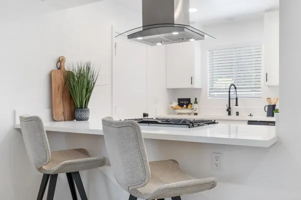 a kitchen with stainless steel appliances a sink a table and chairs