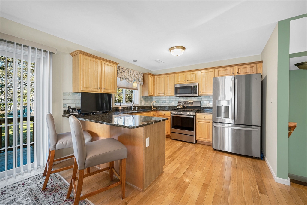 262 Littleton Road, Unit 14 Chelmsford, MA 01824 - Photo 12 of 30 a kitchen with stainless steel appliances a stove a sink dishwasher a refrigerator and a microwave oven with wooden floor