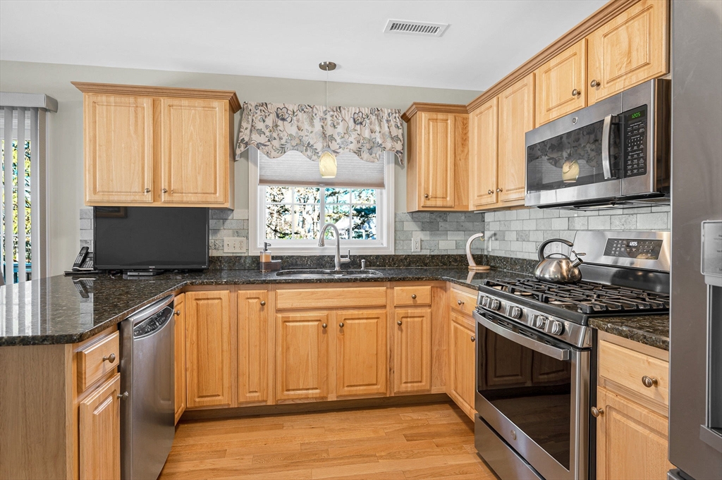262 Littleton Road, Unit 14 Chelmsford, MA 01824 - Photo 13 of 30 a kitchen with stainless steel appliances granite countertop a stove sink and cabinets