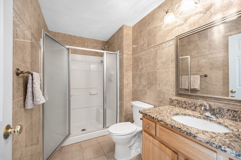 262 Littleton Road, Unit 14 Chelmsford, MA 01824 - Photo 16 of 30 a bathroom with a granite countertop sink toilet and shower