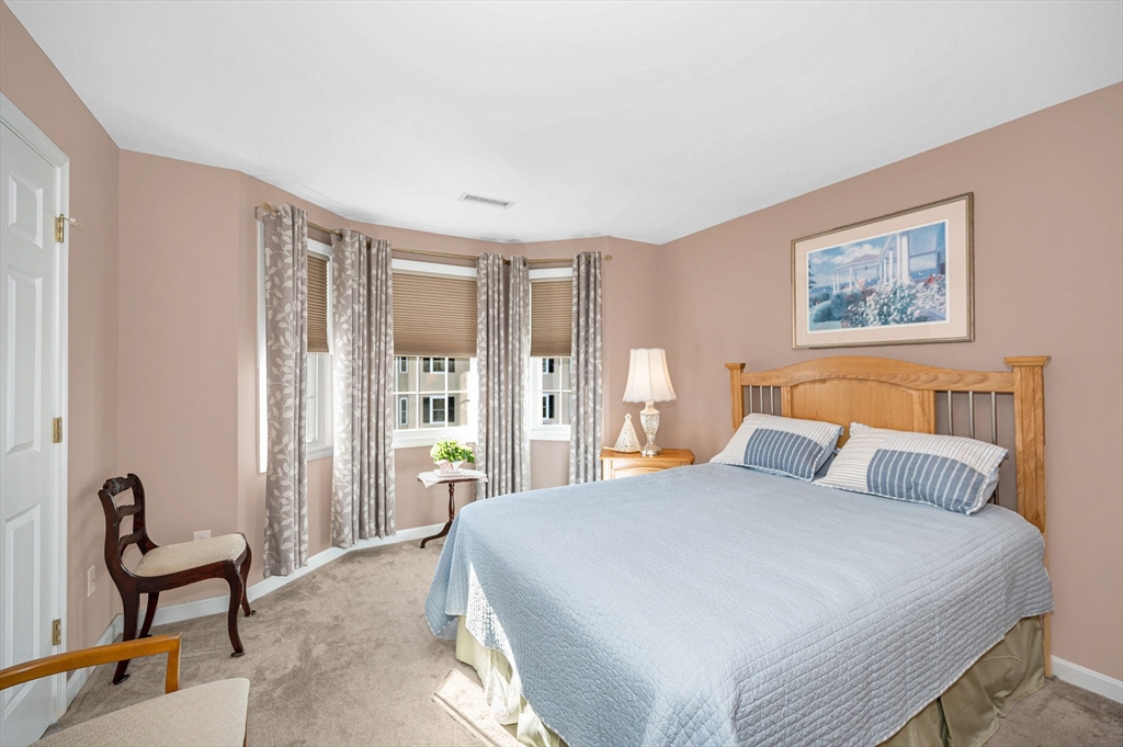 262 Littleton Road, Unit 14 Chelmsford, MA 01824 - Photo 22 of 30 a bedroom with a bed and large windows