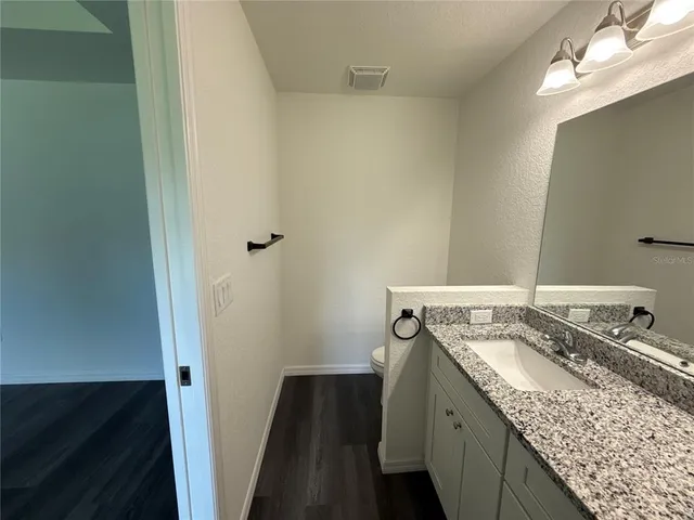 a bathroom with a granite countertop sink and a mirror