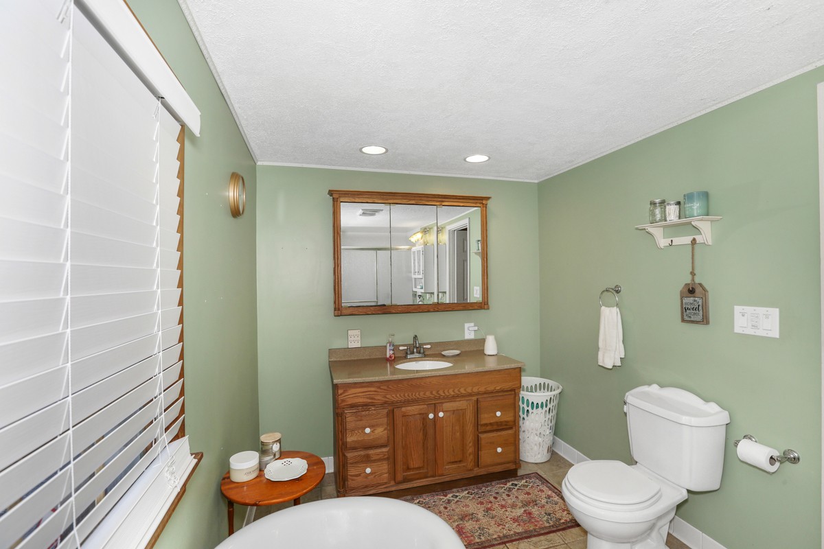 27 Bee Spring Road Dellrose, TN 38453 - Photo 16 of 30 a bathroom with a granite countertop toilet sink and mirror