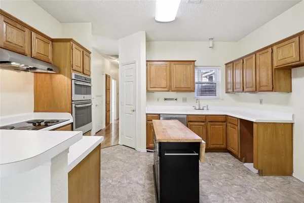 a kitchen with stainless steel appliances granite countertop a stove refrigerator sink and cabinets