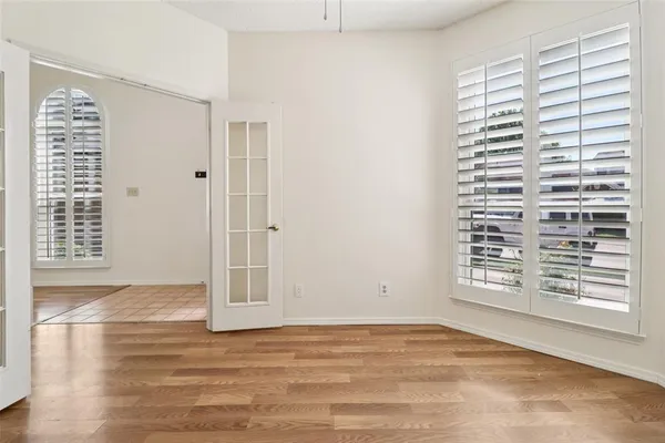 a view of an empty room with a window and a ceiling fan