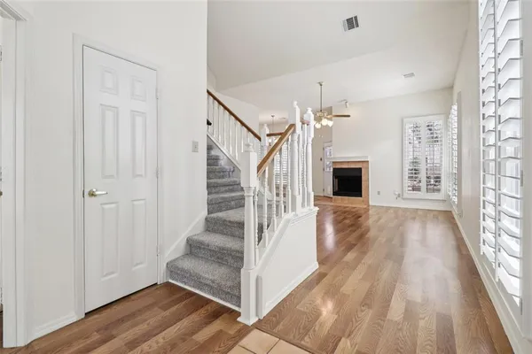 a view of front door with hallway and wooden floor