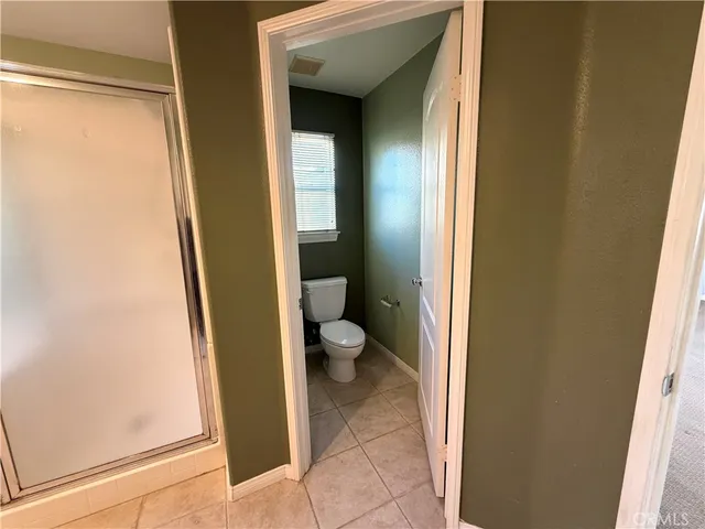 a bathroom with a granite countertop toilet and a sink