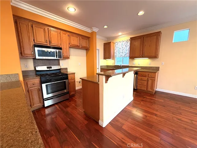 a kitchen with stainless steel appliances granite countertop a stove a sink and a microwave