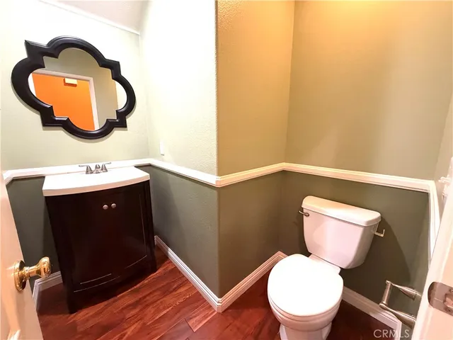 a bathroom with a toilet mirror vanity and a sink