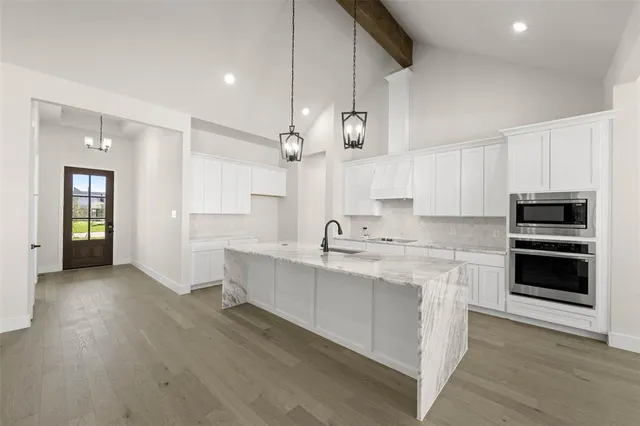 a kitchen with stainless steel appliances kitchen island granite countertop a stove and a sink
