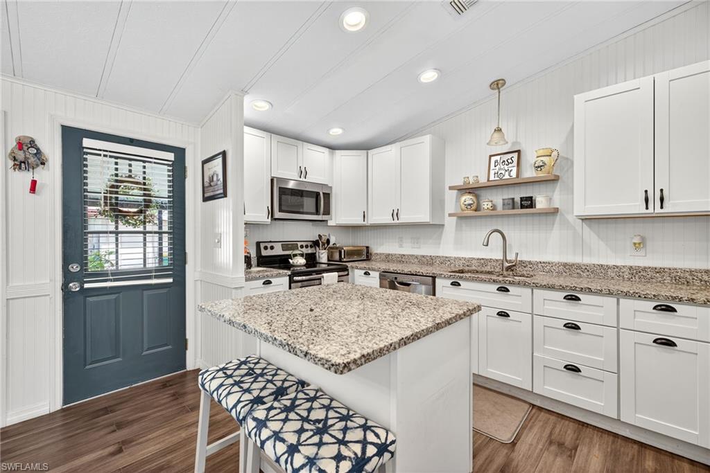 170 Oceans Boulevard, Unit 170 Naples, FL 34104 - Photo 6 of 36 a kitchen with granite countertop a sink stove and cabinets