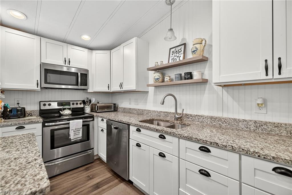 170 Oceans Boulevard, Unit 170 Naples, FL 34104 - Photo 8 of 36 a kitchen with granite countertop white cabinets stainless steel appliances and a sink