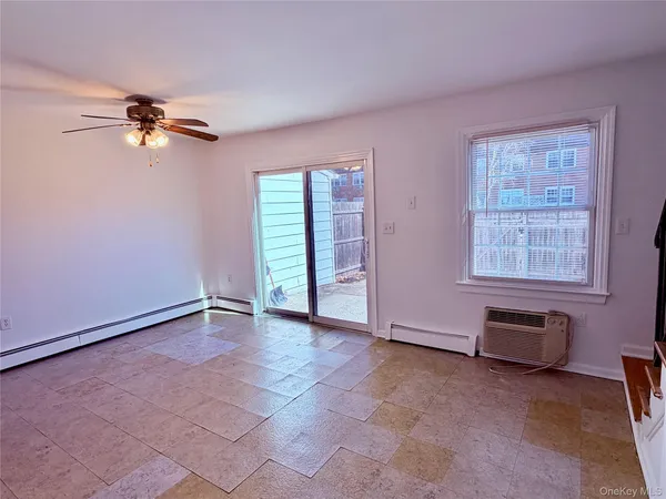 an empty room with windows and ceiling fan