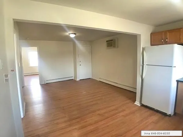 a view of a kitchen with wooden floor and a refrigerator
