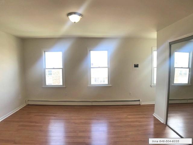 1 McWhorter Street, Unit 1 Newark, NJ 07105 - Photo 8 of 12 an empty room with wooden floor and windows