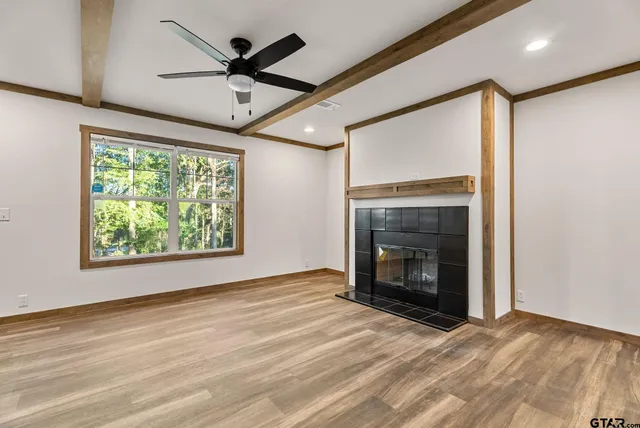 an empty room with ceiling fan and a fireplace