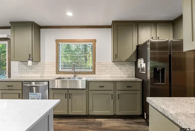 a kitchen with stainless steel appliances granite countertop a sink and a refrigerator