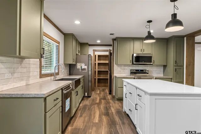 a kitchen with stainless steel appliances a stove sink microwave and cabinets