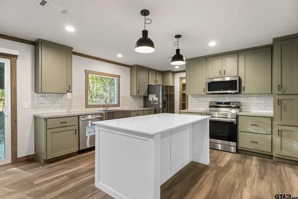 a kitchen with a stove a sink and a refrigerator