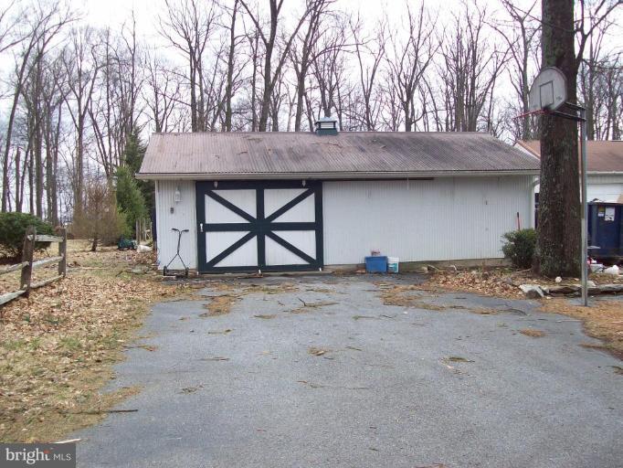 5025 Old Quarter Road Upperco, MD 21155 - Photo 17 of 18 a view of a wooden house with large trees and wooden fence