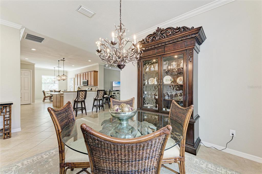 13117 Ramblewood Trail Lakewood Ranch, FL 34211 - Photo 12 of 76 a dining room with furniture a chandelier and wooden floor