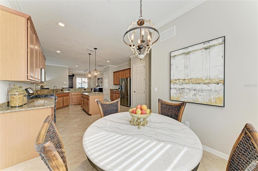 13117 Ramblewood Trail Lakewood Ranch, FL 34211 - Photo 30 of 76 a view of a dining room with furniture a chandelier and wooden floor