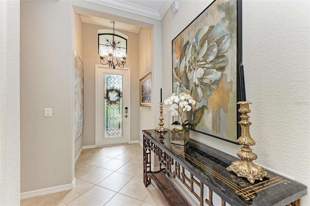 13117 Ramblewood Trail Lakewood Ranch, FL 34211 - Photo 8 of 76 a view of a hallway with wooden floor and a chandelier