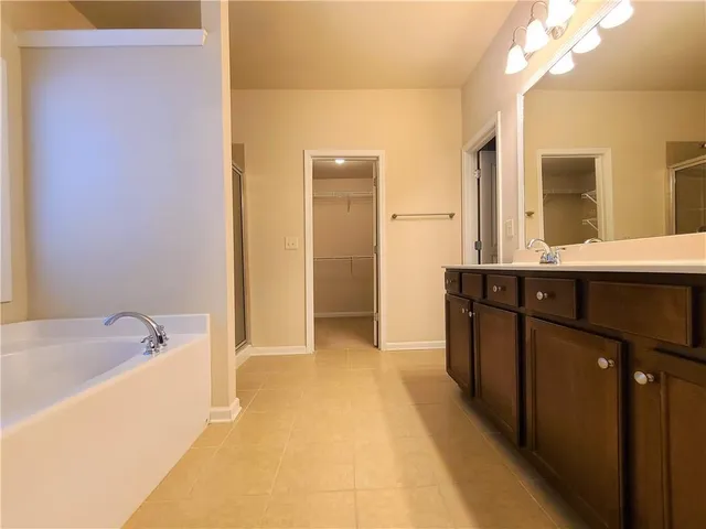 a bathroom with a tub sink and mirror