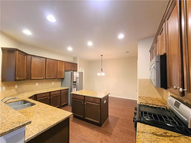 a kitchen with stainless steel appliances granite countertop a sink stove and refrigerator