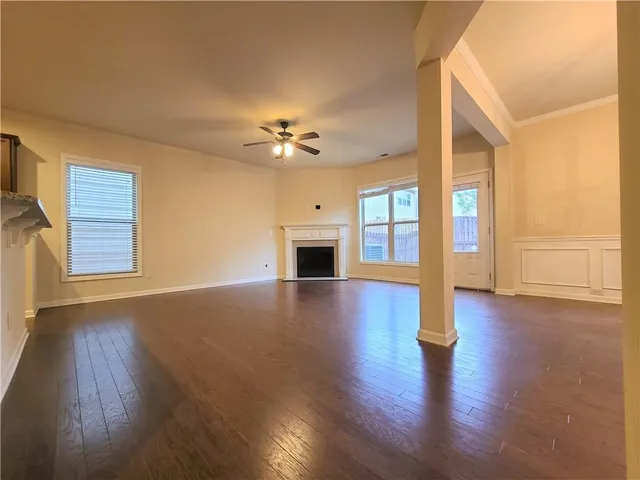 a view of an empty room with a fireplace and wooden floor