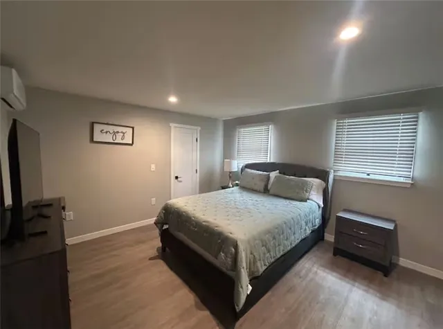 a spacious bedroom with a bed and a tv