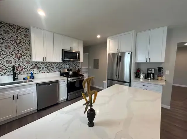 a kitchen with a refrigerator a stove a sink a microwave and cabinets