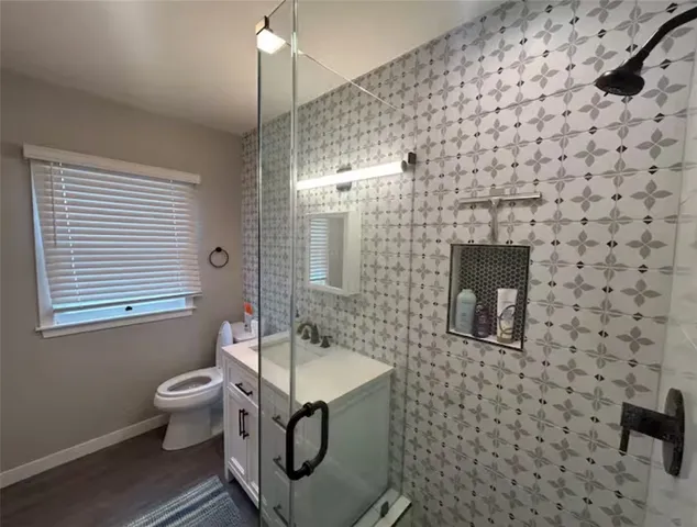 a bathroom with a toilet a sink and mirror