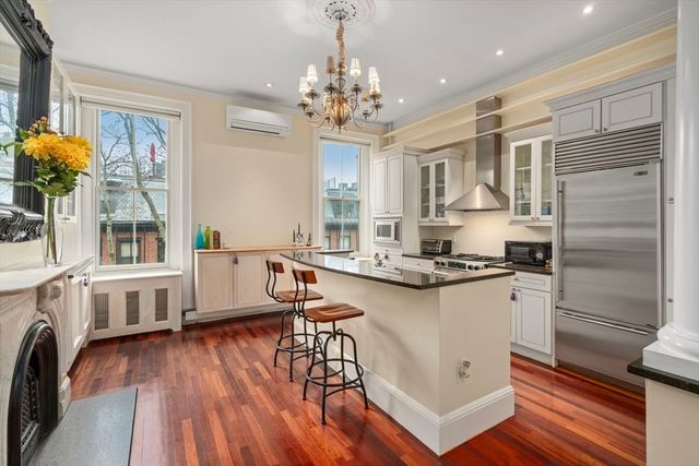 a kitchen with stainless steel appliances a white stove top oven a sink dishwasher and white cabinets with wooden floor