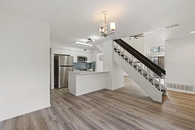 a view of a kitchen with wooden floor and electronic appliances