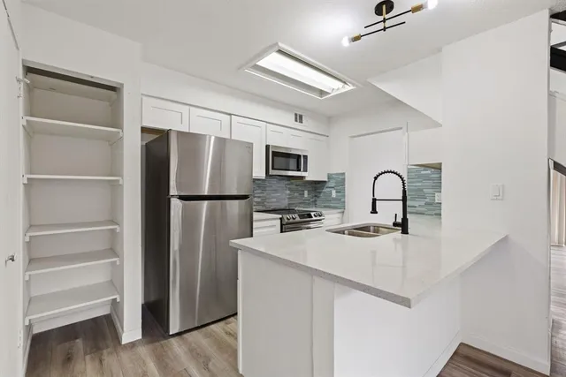 a kitchen with appliances a refrigerator and cabinets