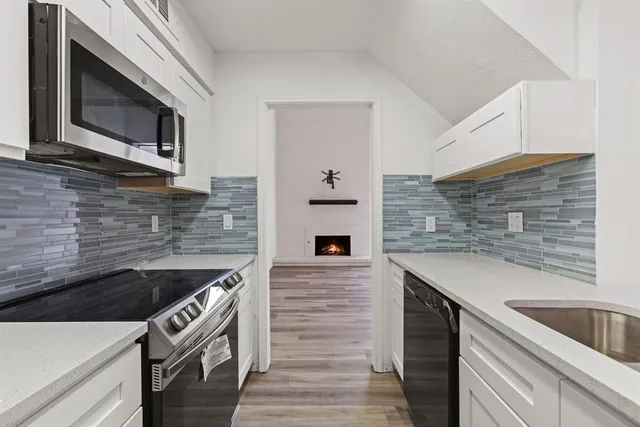 a kitchen with stainless steel appliances kitchen island wooden cabinets and a stove top oven