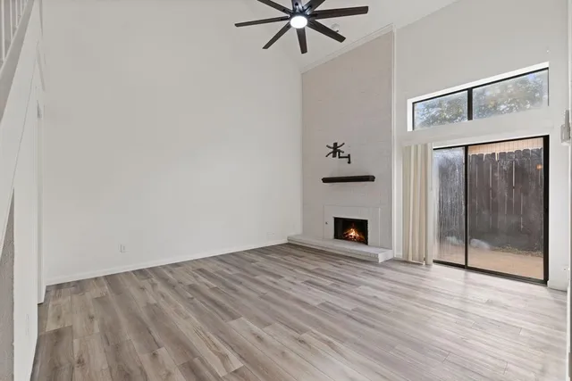 a view of an empty room with a fireplace and a window