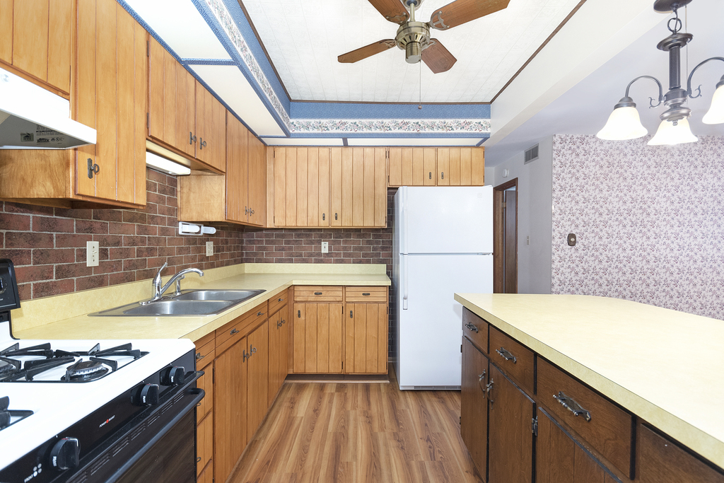 11 Woodcliff Road Montgomery, IL 60538 - Photo 7 of 18 a kitchen with a sink a refrigerator and cabinets