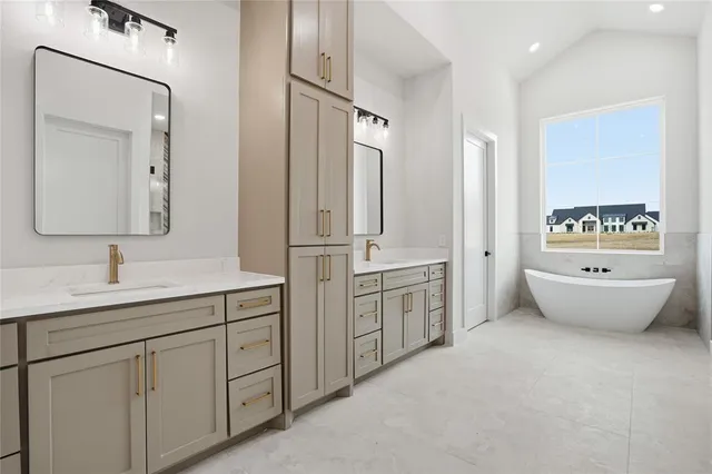 a spacious bathroom with a double vanity sink mirror and bathtub
