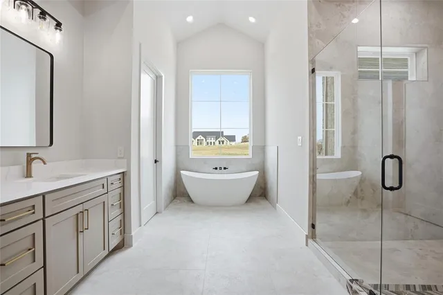 a bathroom with a tub sink and mirror