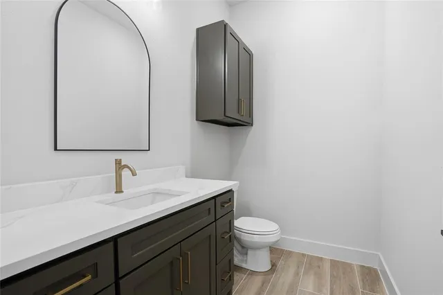 a bathroom with a toilet sink and mirror