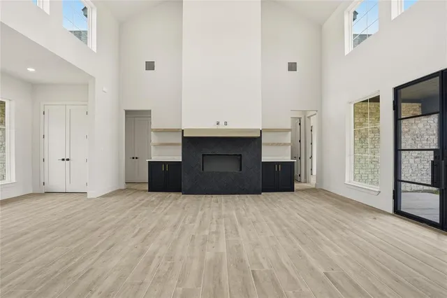 a view of empty room with wooden floor and fireplace