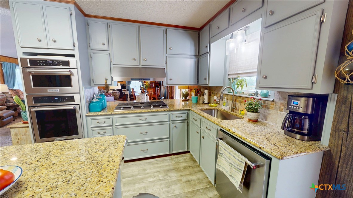 509 Monroe Avenue Port O'Connor, TX 77982 - Photo 26 of 46 a kitchen with granite countertop cabinets stainless steel appliances and a sink